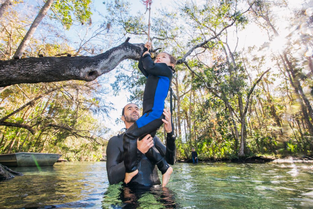 father in river helping daughter in florida springs